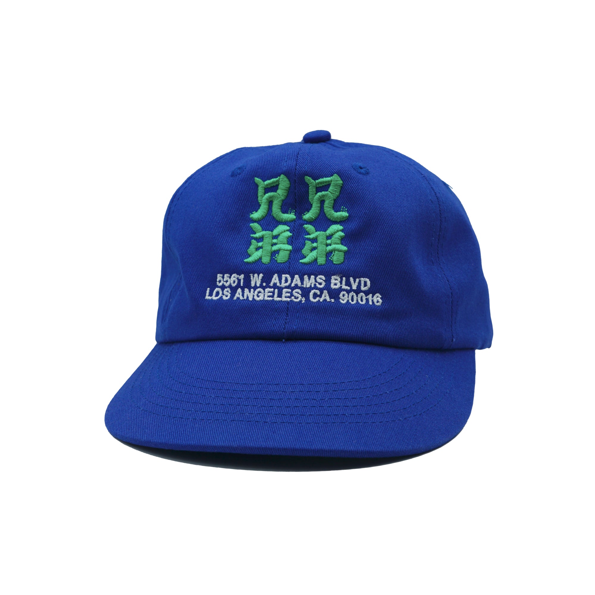 A blue baseball cap with green Japanese kanji characters and English text displaying the shop address on the front.
